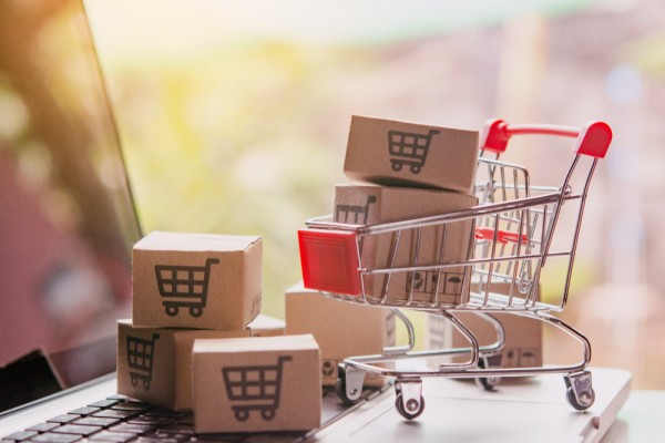 shopping-online-concept-parcel-or-paper-cartons-with-a-shopping-cart-logo-in-a-trolley-on-a-laptop-keyboard-shopping-service-on-the-online-web-offers-home-delivery